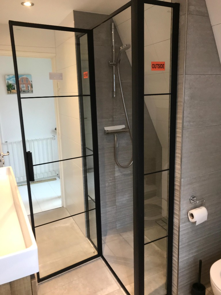 Douchewand met zwart glasprofiel in een moderne badkamer