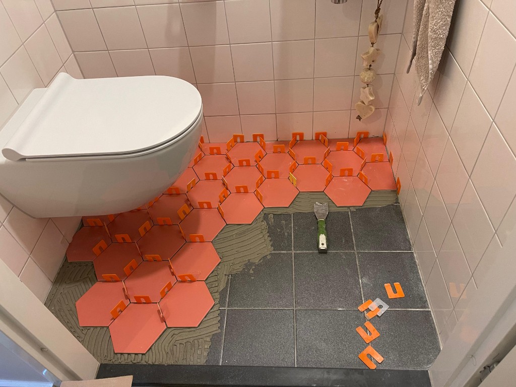 Nieuwe zeshoekige vloertegels: legwerk en afwerking in de badkamer